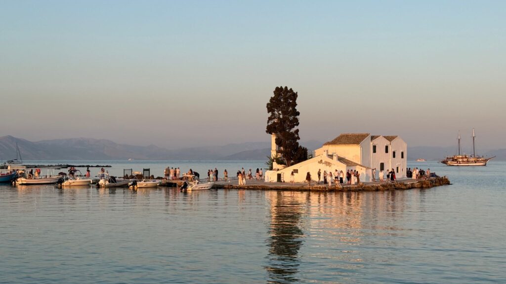 Pontikonisi Mouse Island in Corfu, Greece during golden hour with boats and church