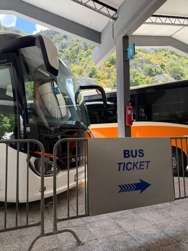 Kotor bus station with sign pointing to where to buy bus ticket