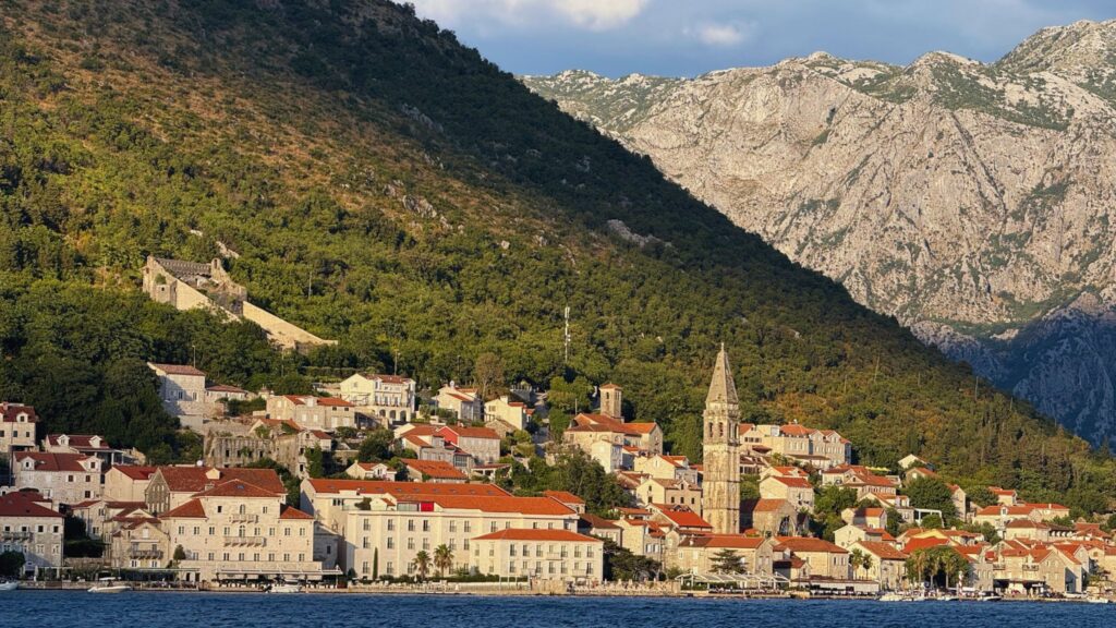 Coastal town of Perast in Montenegro with stone buildings and mountains in the background