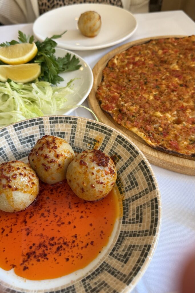 Traditional Turkish mezze spread with hummus, meatballs, flatbread, and fresh salad.