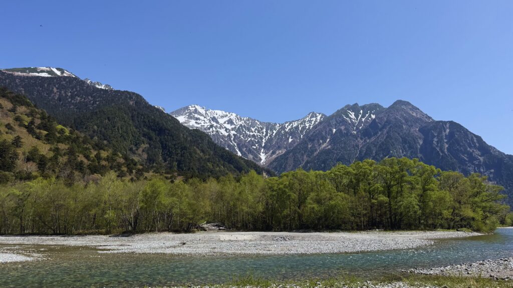 Azusa River flowing through Kamikochi valley with snow-capped Hotaka mountains in the background