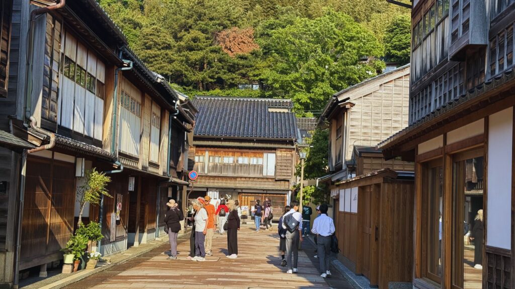 Visitors strolling along the historic wooden streetscape of Higashi Chaya geisha district in Kanazawa