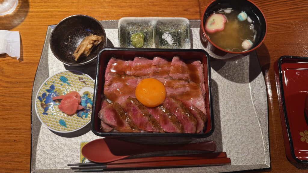 Wagyu beef donburi with egg yolk served with miso soup and small sides in Kanazawa