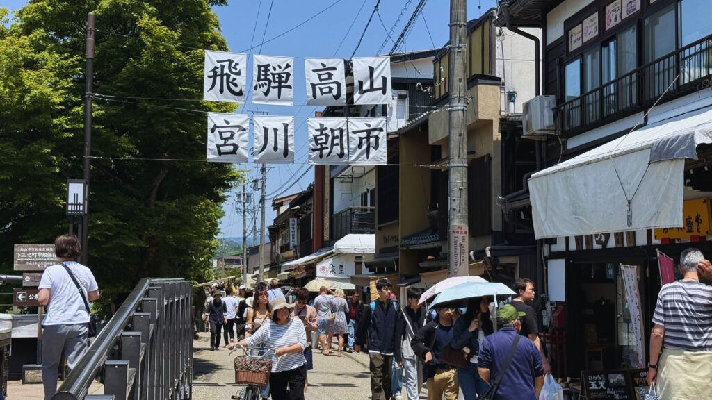 Busy Miyagawa Morning Market in Takayama with traditional banners