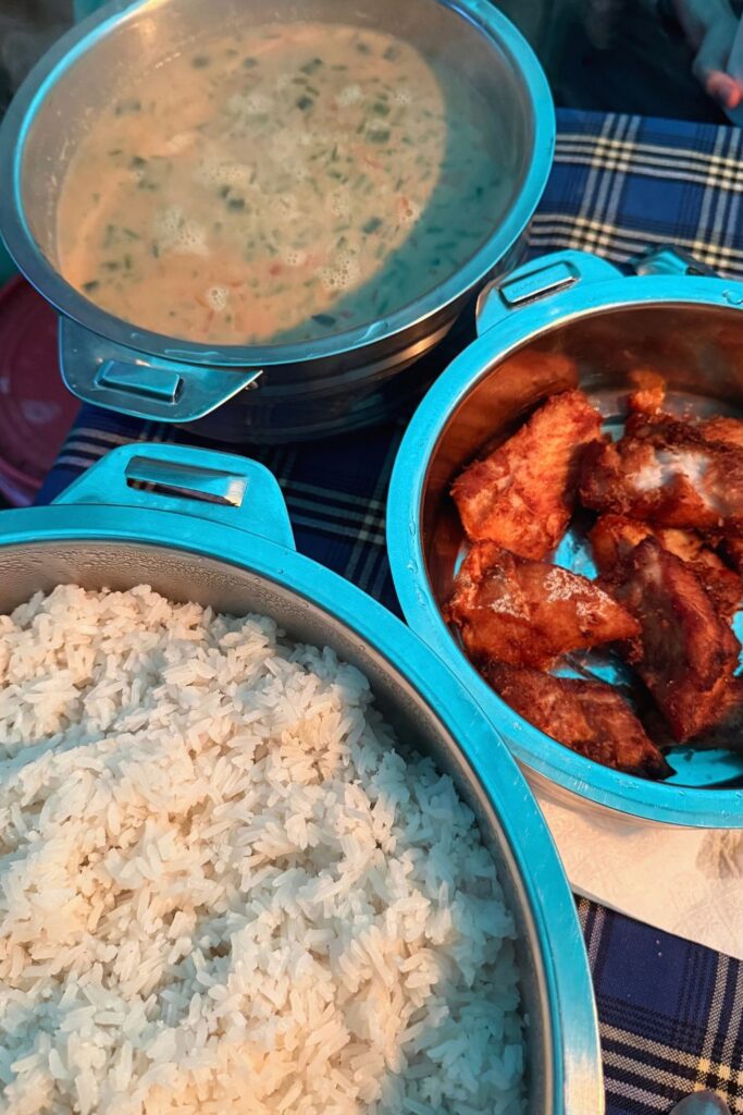 A hot camp dinner of rice, fried chicken, and soup served on the Lemosho Route