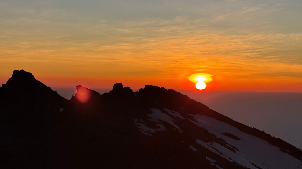 Sunrise silhouette over Kilimanjaro's rocky summit ridge