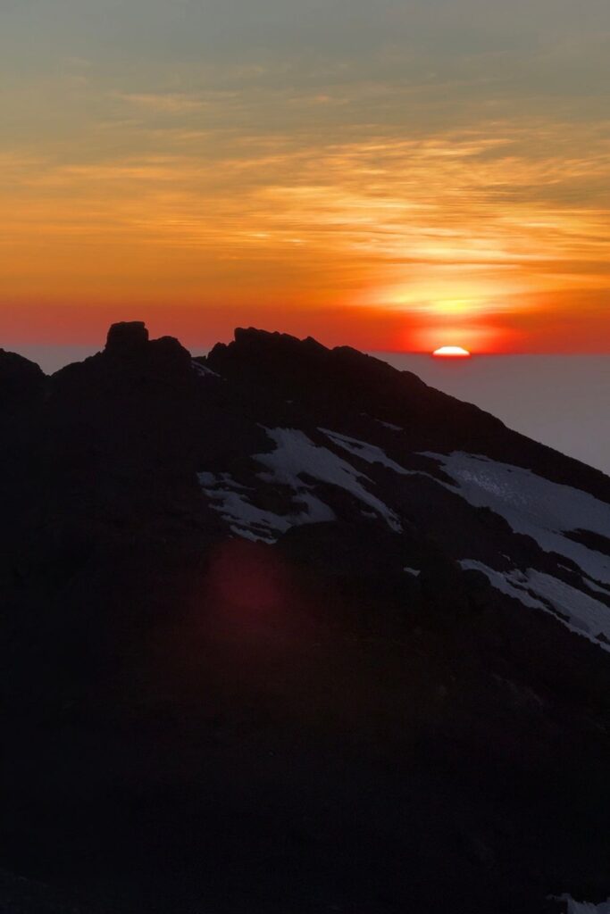 Sunrise breaking over the ridge during the summit night hike to Uhuru Peak
