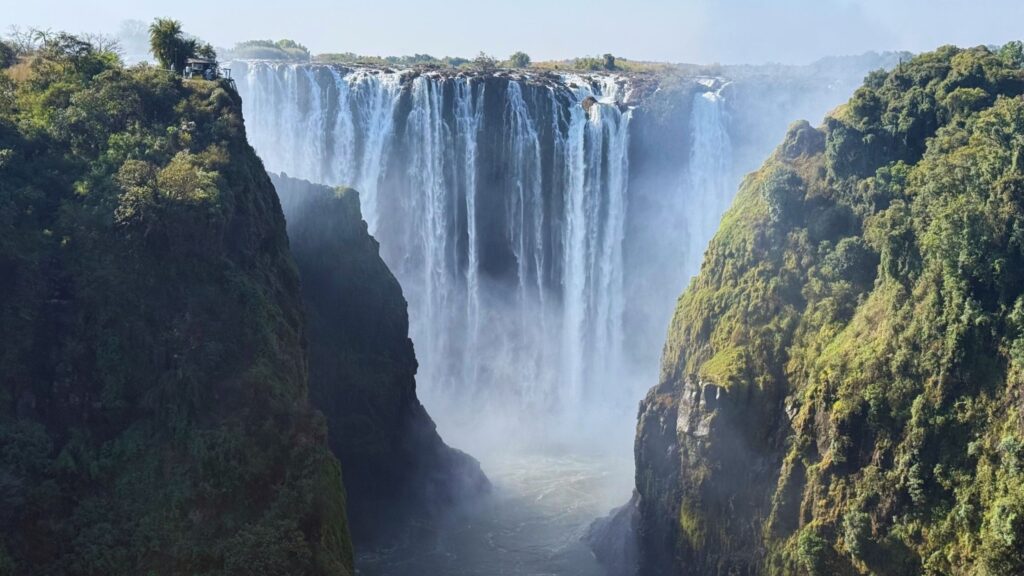 Victoria Falls pouring into the green Zambezi gorge between Zambia and Zimbabwe on a clear day